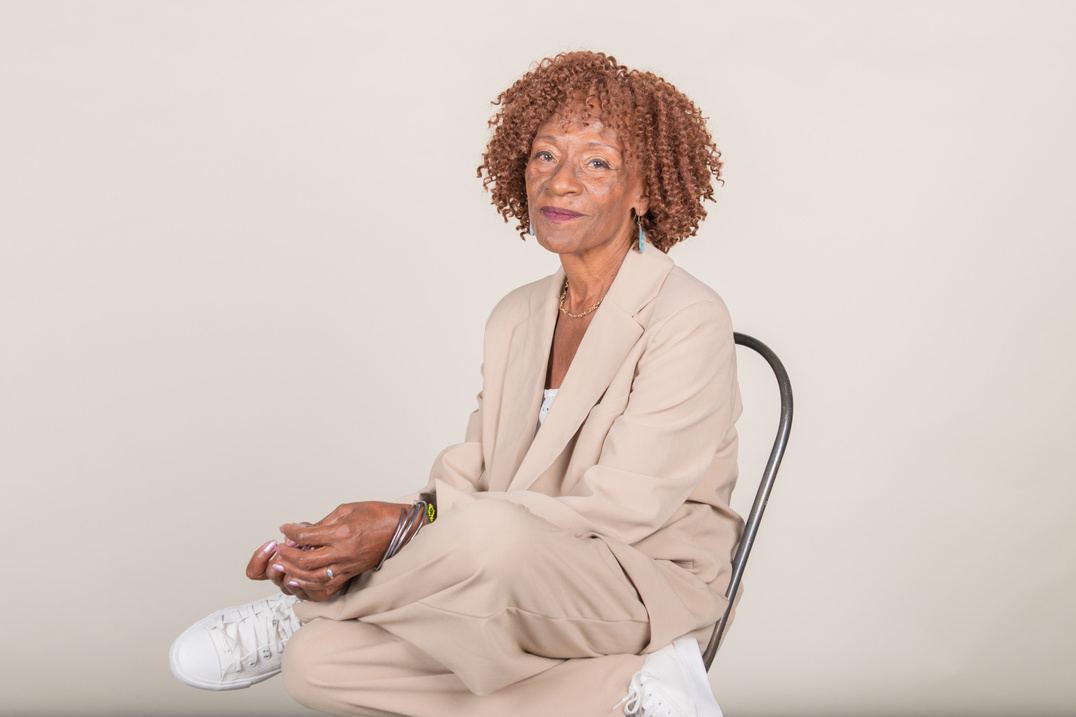 Stylish Senior Woman Sitting on a Chair on White Background