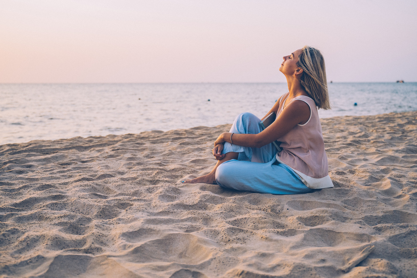 A Blonde Woman Relaxing on the Beach