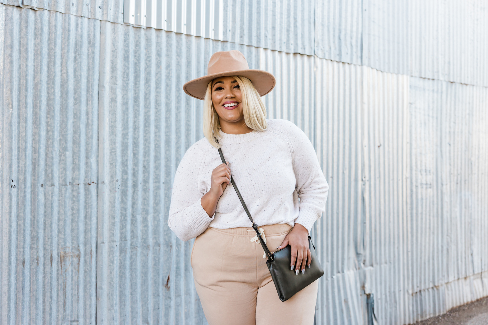 Stylish Plus Sized Woman Posing Near Corrugated Metal Wall